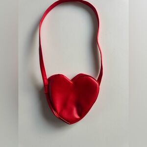 Red heart-shaped shoulder bag with snap closure